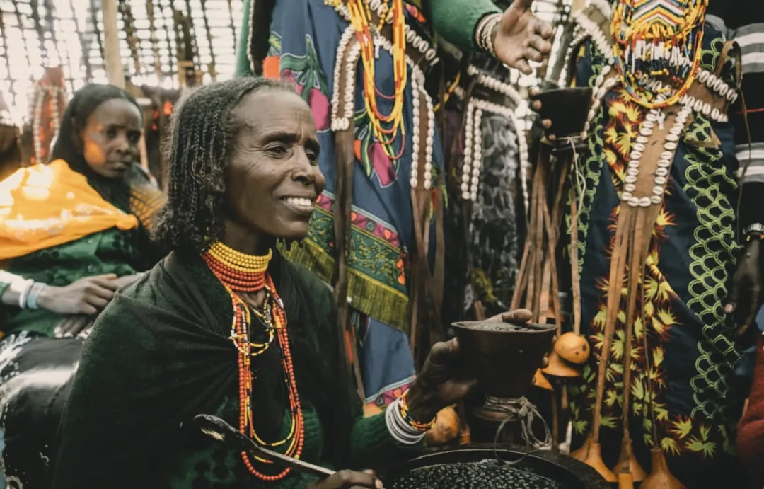 Women are the traditional hosts and moral anchors of Buna Kela. Their hands roast, grind, and pour — but their wisdom guides the circle toward peace and dignity.